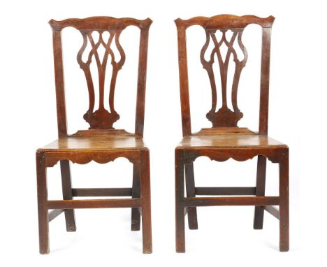 A pair of George III fruitwood country Chippendale style side chairs, each with a pierced splat, above a solid seat and a wav