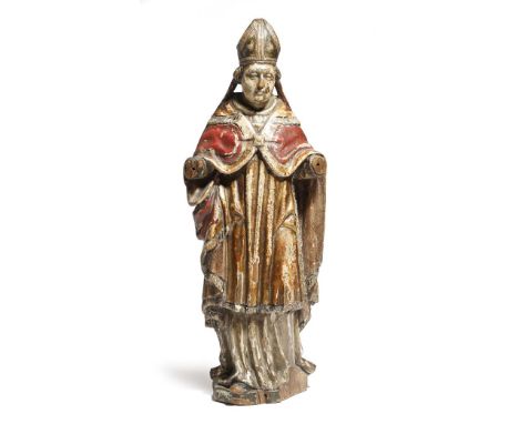 A continental carved wood and polychrome decorated figure of a bishop, with parcel gilt decoration, wearing a mitre and a red