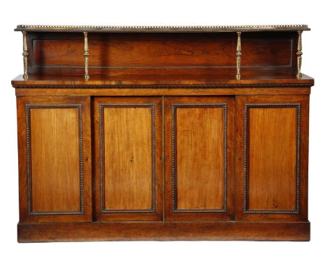 λ A Regency rosewood side cabinet, with nulled decoration, the raised top with a gilt brass gallery and leaf decorated suppor