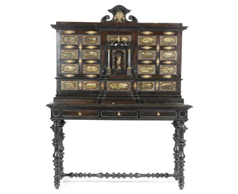 An Italian Baroque style ebonised cabinet, with brass mounts and ripple mouldings, with a scroll pediment applied with a pair