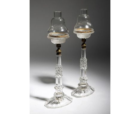 A pair of late Victorian cut-glass cricklite candle lamps, each with a detachable shade, with an engine turned brass mount in