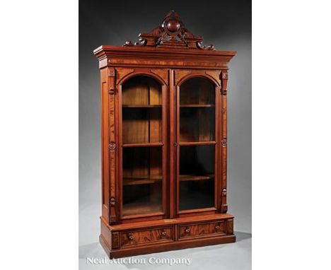 American Renaissance Carved and Burled Walnut Bookcase , late 19th c., stepped cornice centering a relief-carved globe, teles