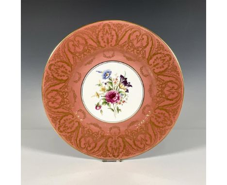 This bone china dinner plate features a bouquet of flowers in the center with a coral and gold pattern around the edge. Gloss