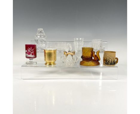 A set of 9 unique toothpick holders, including a red one with frosted forest animals, a brown tyg with duck shaped handles, a