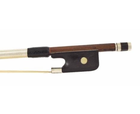 Violin bow stamped Emille Ouchard, the stick round, the ebony frog inlaid with pearl eyes and the ebony adjuster with two met