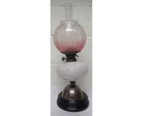 Victorian oil lamp with a white glass reservoir with repousse decoration, together with chimney and a pink and clear glass sh