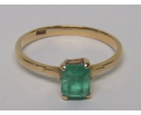 A marked 18ct gold dress ring set with a step cut emerald, measuring approximately 5.8mm x 4.8mm, ring size N 1/2, weight 2.1