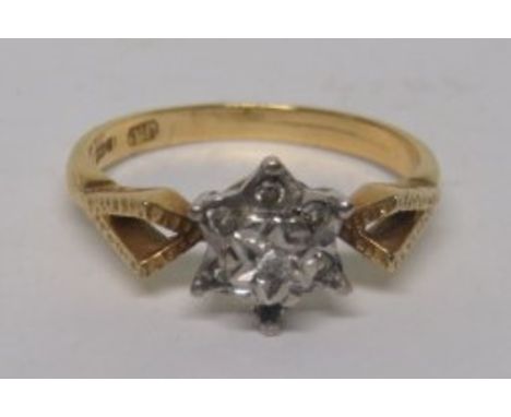 A marked 18ct gold illusion set diamond ring in a platinum flower, with a yellow gold shank, and pierced shoulders, ring size