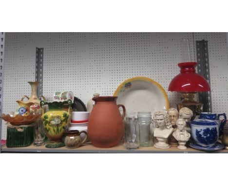An oil lamp with a red shade, together with a quantity of ceramics and glassware