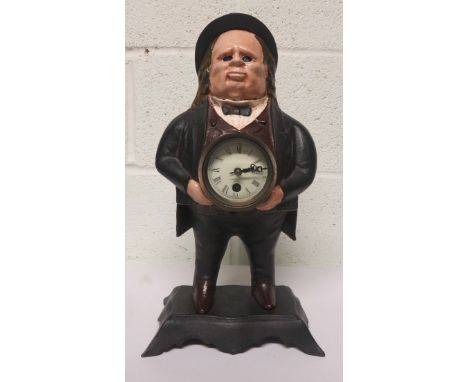 Novelty cast iron clock of a gentleman wearing a bowler hat, holding the clock face