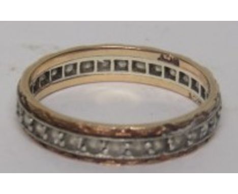 An unmarked yellow metal and white stone eternity ring, ring size N 1/2, weight 2g 