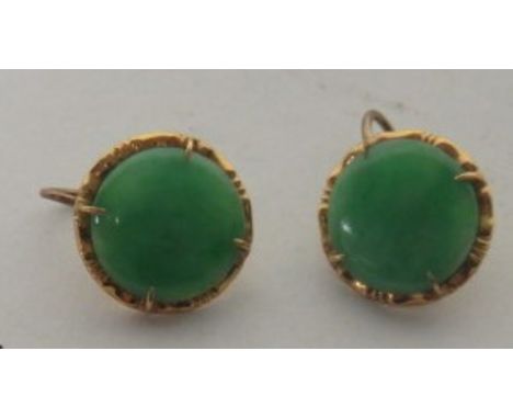 A pair of circular jade earrings with an unmarked 18ct gold (tested) surround, measuring approximately 13mm in diameter Condi