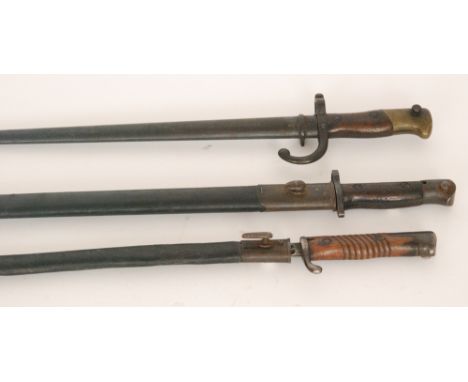 A 19th Century French socket bayonet and scabbard, another stamped L.GG.R.7.63 and a 1907 Sanderson pattern bayonet and scabb