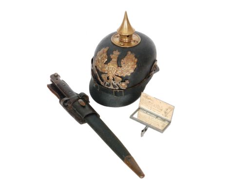 A First World War Prussian Pickelhaube helmet in black leather, lined interior, together with a 1903 pattern bayonet and scab