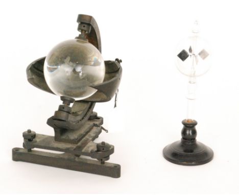 A mid 20th Century sunshine recorder by Negretti and Zambra London with revolving glass sphere on an ebonised cast iron stand