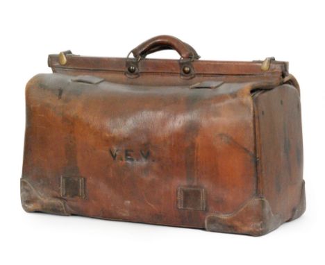 A large Edwardian brown leather Gladstone type bag with cantilever action and oval makers plaque to base John Parsons and Son