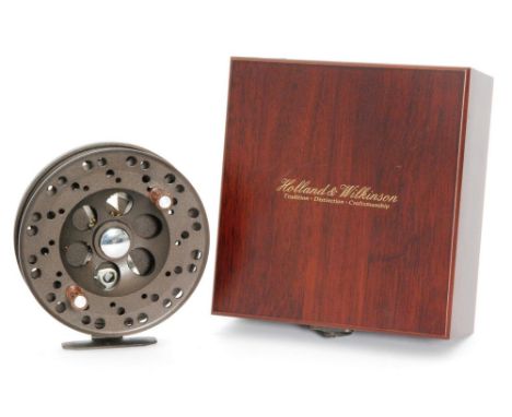 A centre pin trout fishing reel by Holland and Wilkinson in mahogany finish case.