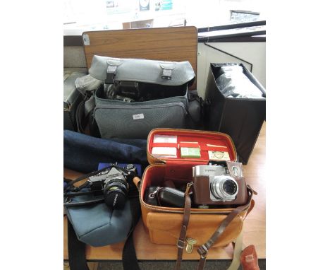 A collection of camera equipment including Olympus OM-1, camera bag containing Tamron 80-210 tele macro zoom lens, model 03A,