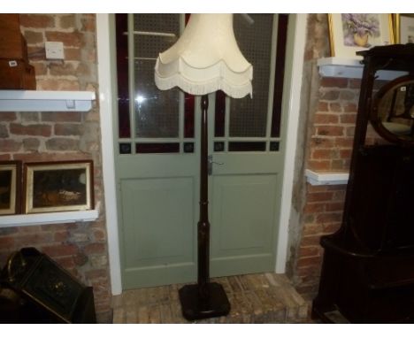 A mid 20th century standard lamp with carved decoration to pillar and base, elegant shade 