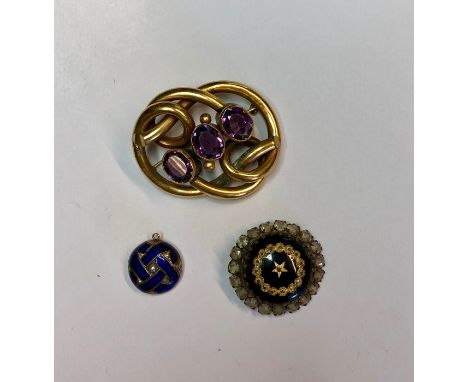 A Victorian gilt metal scroll brooch set with three oval amethysts, a part locket set blue enamel with central half pearl and
