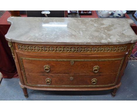 A continental grey marble top gilt-metal mounted kingwood commode with three drawers, raised on fluted turned legs, early 20t