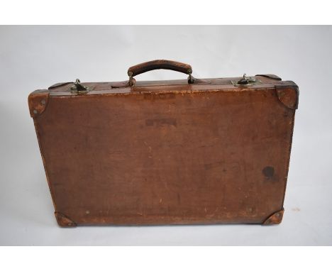 A vintage heavy leather suitcase with red interior and maker's label, Moritz Madler, Leipxig
