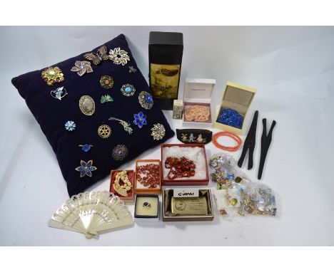 A collection of costume jewellery brooches, some enamel, some paste set, pinned to a cushion to/w various bead necklaces, qua