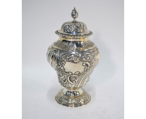 A late Victorian silver rococo revival baluster tea caddy, the domed cover with pine-cone finial, the writhen fluted body emb