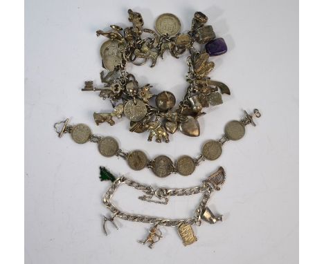 A vintage white metal charm bracelet with approx thirty-five various charms attached including coins, poodle, elephant, car, 