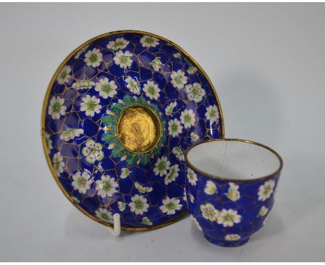 A late 19th or early 20th century Chinese Canton enamel tea bowl and saucer, decorated with a gilt highlighted floral design 