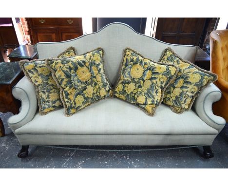 A Queen Anne style hump back sofa with scroll arms, raised on moulded mahogany front legs to castors, c/w four contrasting sc