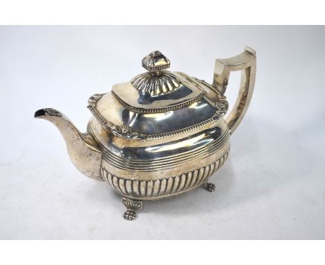A Regency Irish silver teapot of oblong form, half reeded and with banded reedng, cushion finial and egg and dart rims, on pa
