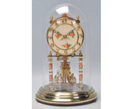 A vintage 20th Century German Kundo brass anniversary mantel clock having a a cream enamelled face with re floral decoration 