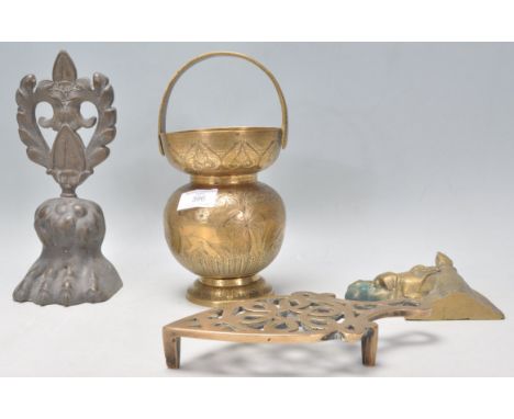 A collection of brass wares to include an antique lions paw and crest door stop, Indian brass vessel of bulbous form engraved