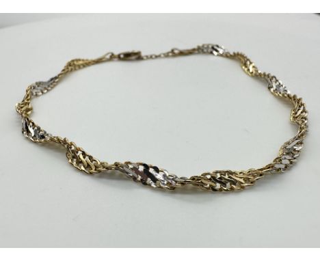 A 9ct yellow and white gold fancy twist bracelet, light weight, approx weight 1.8 grams, 8 + 1/2 inches long,