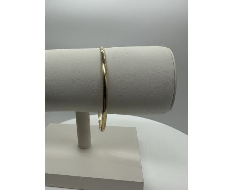 A 9ct yellow gold solid D shape bangle, 2+1/2 mm wide, approx weight 8.4 grams, 2+1/2 inches diameter 