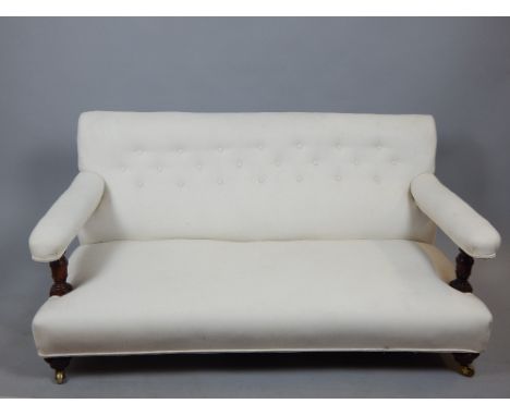 Late 19th C fireside sofa, buttonback calico with padded arms, turned mahogany supports and feet, approx. 145cm w.