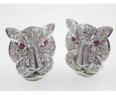 A pair of diamond a ruby earrings shaped as cougars in white gold. The face of the cat set with round cut diamonds, each with