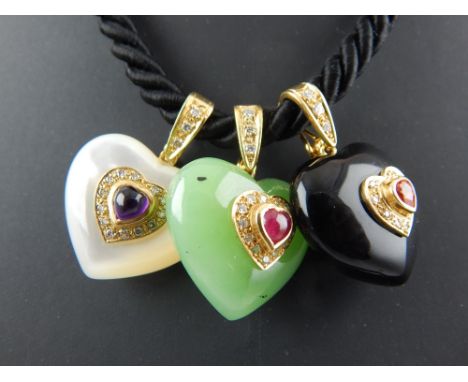 A black onyx, jade and mother of pearl heart necklace. The cabochon cut hearts suspended from a black rope chain by 18ct yell