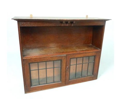 Arts & Crafts style oak wall cabinet of serpentine form with shelf above a pair of astragal doors, 74cm w.