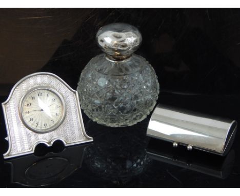 George V turned silver bedside timepiece frame, a silver mounted scent bottle and a plated compact.