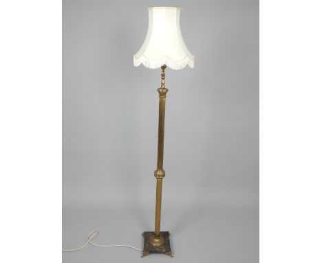 Gilt metal standard lamp and shade, the knopped column on square marble base with cast floral scroll feet.