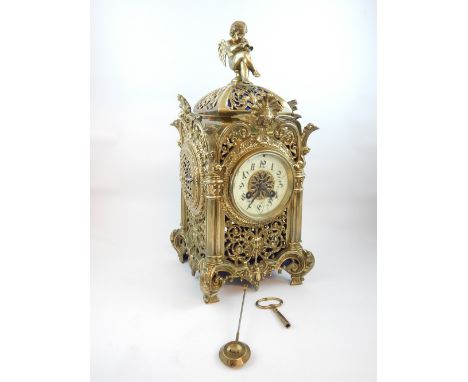 French late 19th C mantel clock, brass cherub finial, all over floral decoration, cherub masks. Pierced roundel windows and f