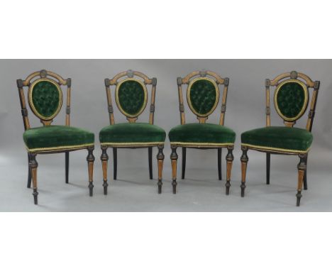 A set of four Victorian aesthetic ebonised dining chairs, burr walnut inlaid, green velour button back upholstery, raised on 