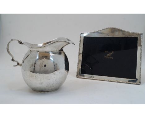 A 900 standard jug, possibly Peruvian, with scrolling handle, 16cm high; together with an Indian photo frame, by Cooke & Kelv