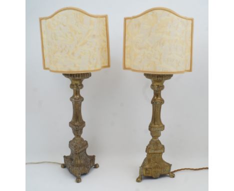 A pair of brass candlestick table lamps, 20th century, of columnar form with tripod legs and claw feet, converted for electri