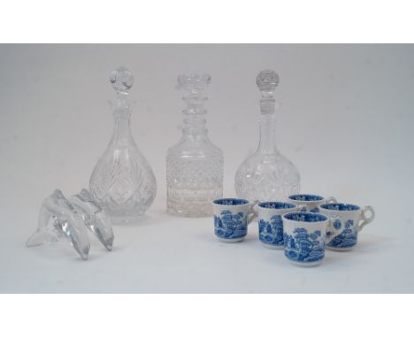 Three glass decanters and stoppers, tallest 28cm high, together with a pair of satin cushions embroidered with flowers and mu