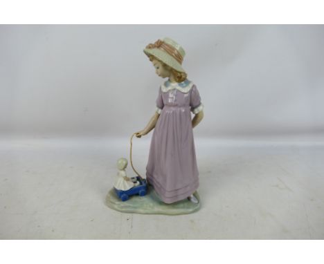 A Lladro figure depicting a young girl pulling a doll in a toy wagon, # 5044, approximately 27 cm (h). [W]