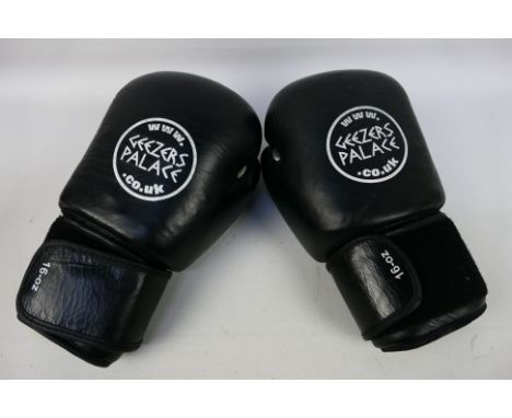 A pair of 16 oz Geezers Palace boxing gloves in black and white. [W]