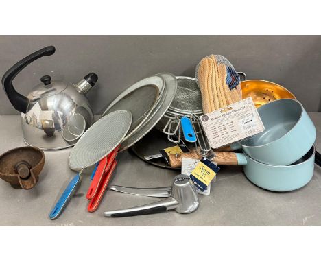 A selection of cookware to include two sieves, pans and a kettle 